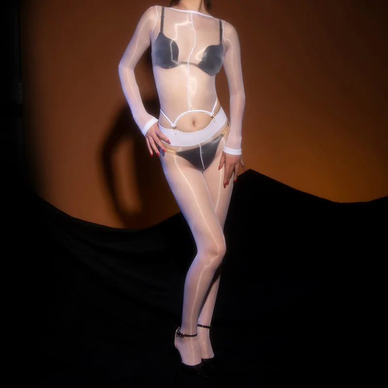 A woman posing in a white glossy sheer long sleeve top with gartered bodice with matching glossy pantyhose.