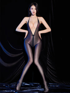 A woman posing in a sheer glossy black bodystocking with deep plunge halter neckline, front to back zipper closure and closed feet.