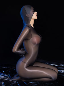 A women posing in a black glossy sheer bodystocking with long sleeves, closed hand design, attached over the head hood, and open crotch.