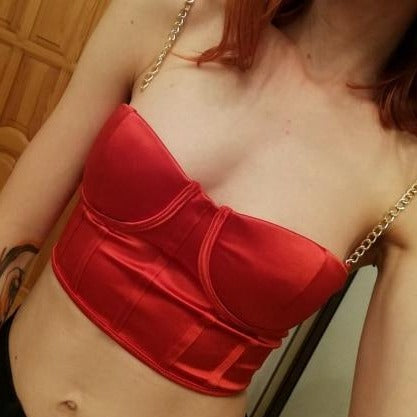 Red sexy corset crop top featuring a adjustable shoulder straps, back zipper closure and a low cut back. 