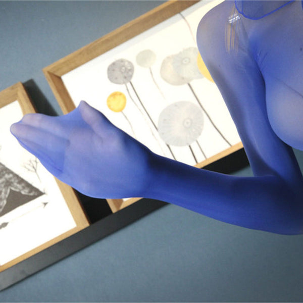 Close up view of lady hands wearing blue shiny long sleeve glossy sheer dress that has a sheer hood and closed hands. 